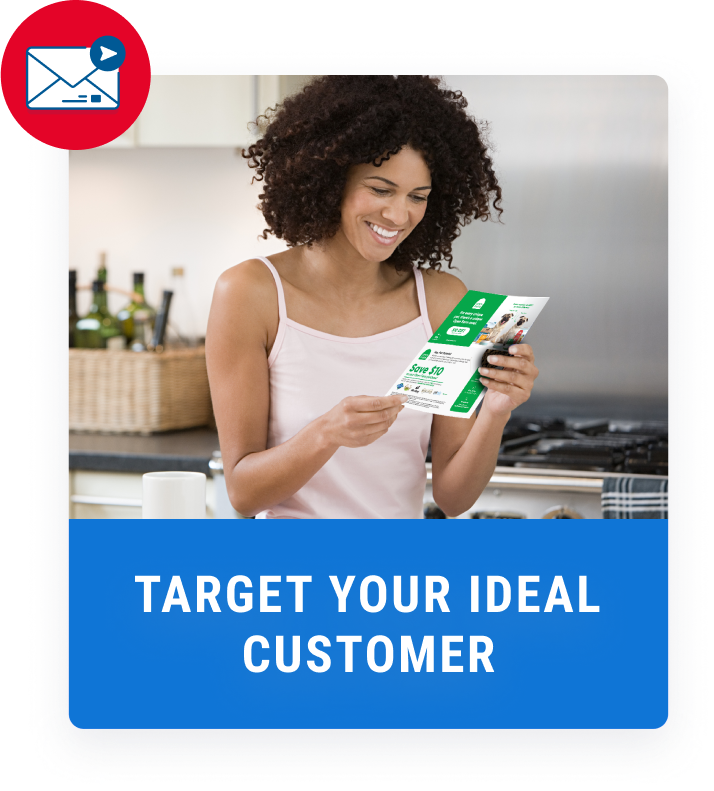 woman in kitchen smiling while reading a green coupon flyer